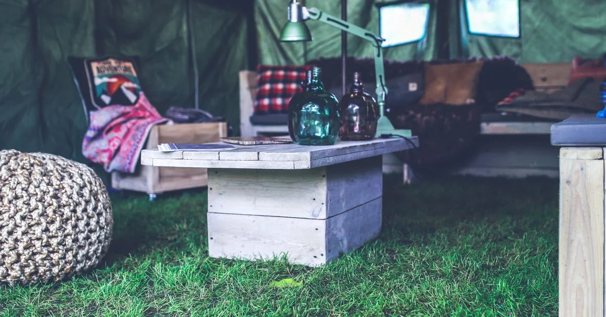 Une tente intérieure cosy décorée avec des meubles rustiques, parfaite pour une ambiance de camping.
