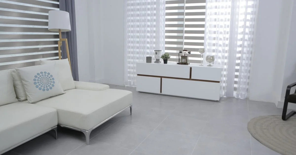 Salon lumineux et spacieux avec décor moderne minimaliste, un canapé blanc et des meubles élégants.