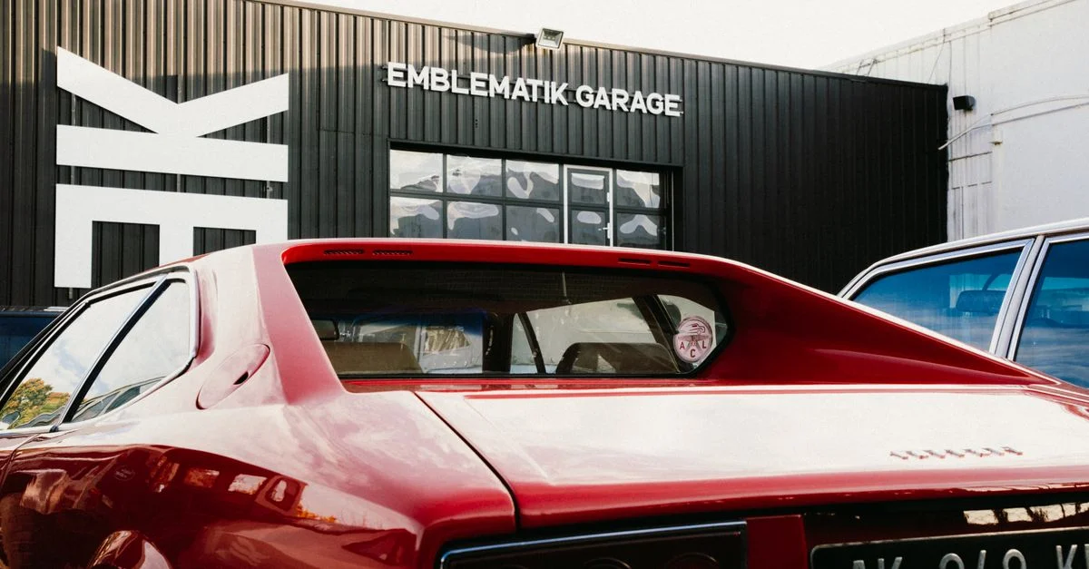 Une voiture rouge vintage garée au garage Emblematik à Montigny-le-Bretonneux, France.