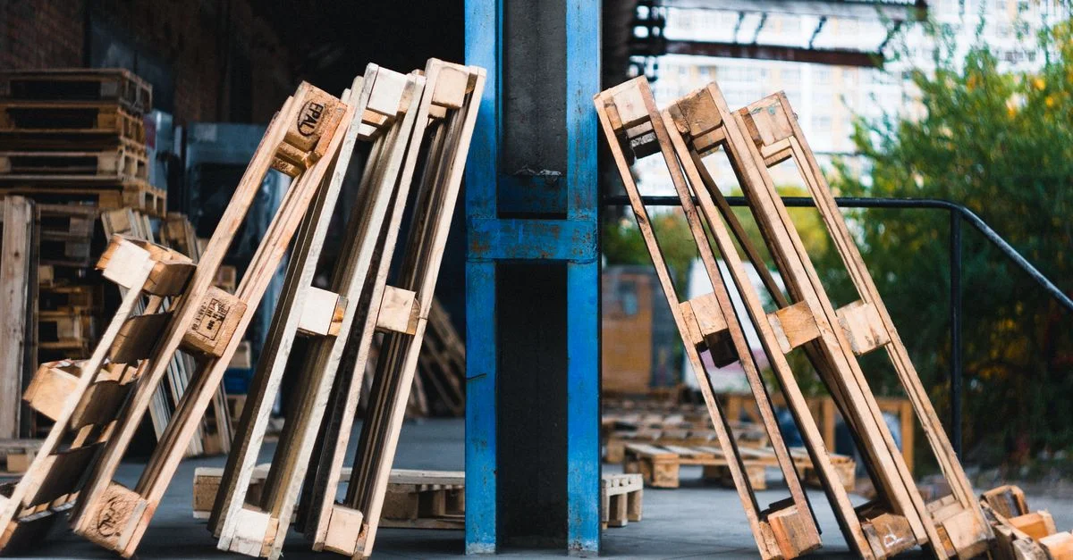 Vue en gros plan de palettes en bois dans un entrepôt industriel extérieur.