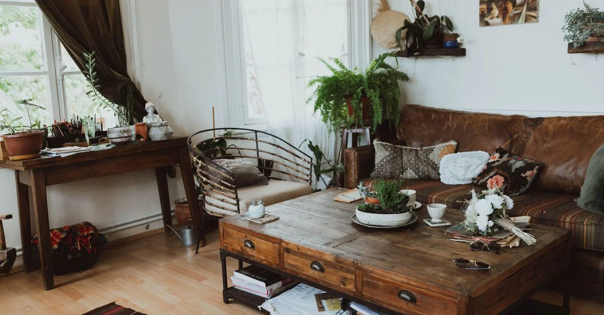 Un salon douillet avec des meubles vintage, une décoration rustique et des plantes d'intérieur créant une ambiance chaleureuse.