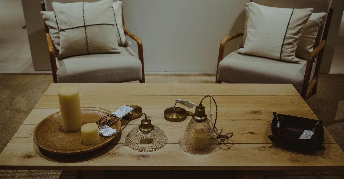 Une scène élégante de salon avec des fauteuils, des lampes et des bougies sur une table en bois.