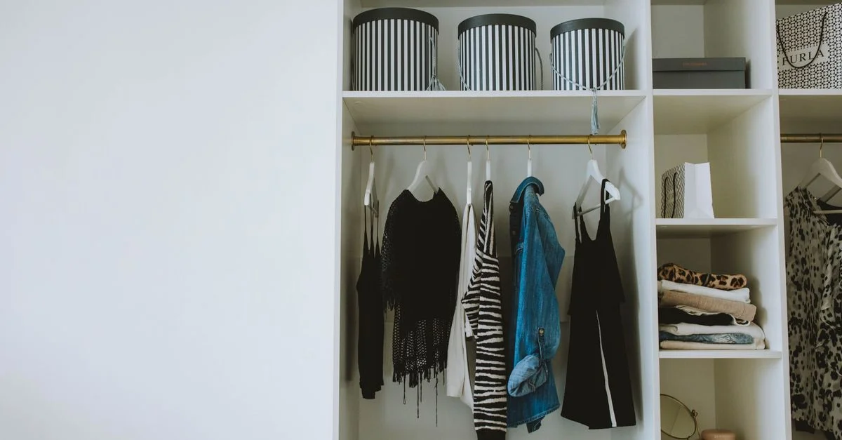 Garde-robe organisée avec des vêtements tendance, des cintres et des boîtes de rangement.
